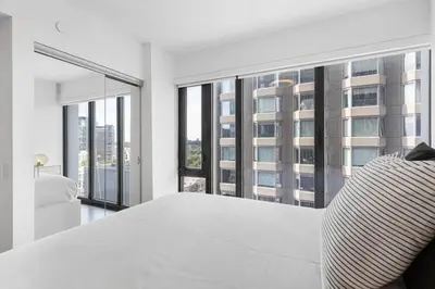 a bedroom with a large white bed and large windows at Executive 1BR-1BA Condo in the heart of downtown in Toronto