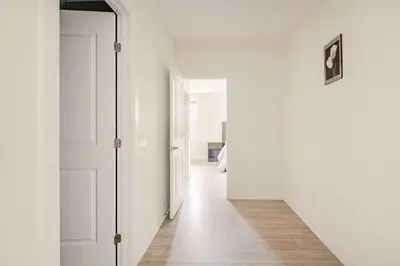 a hallway with white walls and a wooden floor at The Residence, Your comfort is our culture in Oakville
