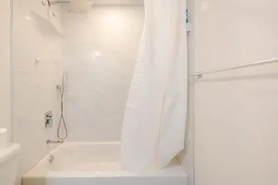 a bathroom with a shower with a white tub at The Residence, Your comfort is our culture in Oakville