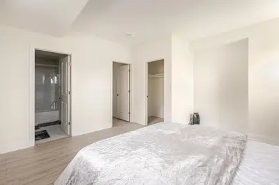 a white bedroom with white walls and a bed at The Residence, Your comfort is our culture in Oakville