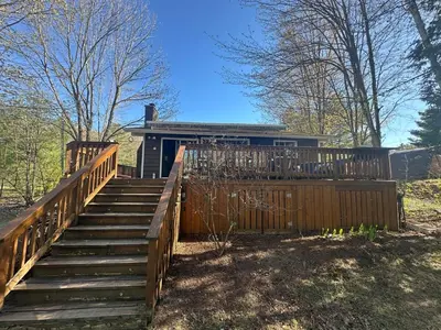 a house with a wooden staircase leading to a house at Cozy lakeside Cottage on 3 Mile Lake with Wifi in Windermere