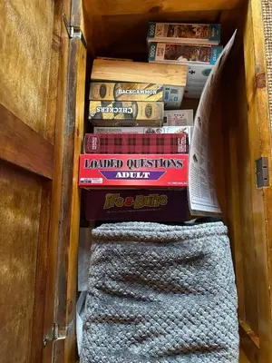 a stack of books in a drawer with a stack at Cozy lakeside Cottage on 3 Mile Lake with Wifi in Windermere