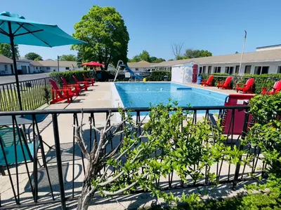 a swimming pool with chairs and an umbrella at Holiday Home 7865LL in Niagara Falls