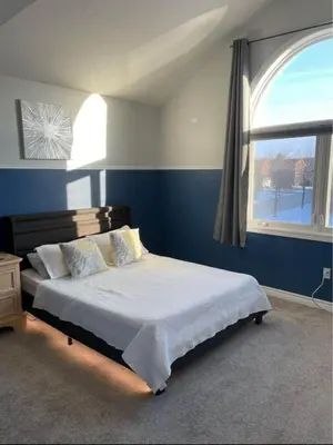 a bedroom with a large bed with a window at Serene Bedroom with Private Ensuite in Georgina