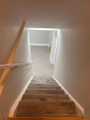a hallway with a staircase with wooden floors at The Sleek Shelter in Milton