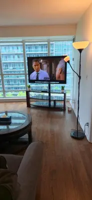a living room with a large flat screen tv at Lovely condo near Lake Ontario in Toronto