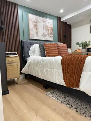 a bedroom with a large bed and a night stand at Luxurious Home Away From Home in Pickering