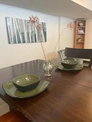 a wooden table with two bowls and plates on it at Entire Apartment in Guelph
