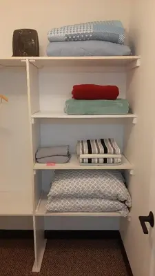 a shelf with towels and pillows in a room at Entire Apartment in Guelph