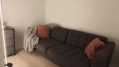 a living room with a brown couch with pillows at Reno'd Suite Steps to CN Tower - Free Parking in Toronto