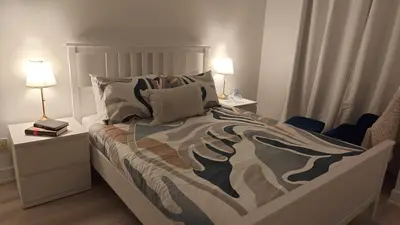 a bedroom with a bed and two nightstands and two lamps at Reno'd Suite Steps to CN Tower - Free Parking in Toronto