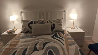 a bedroom with a large bed with two lamps at Reno'd Suite Steps to CN Tower - Free Parking in Toronto
