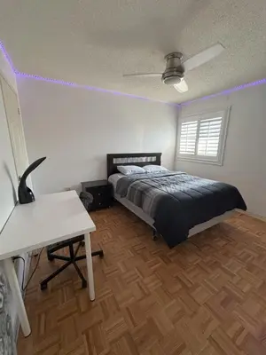 a bedroom with a bed and a desk with purple lights at Pearson Gateway Comfort Home in Mississauga