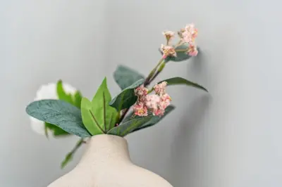 a person holding a plant with pink flowers in a vase at Prime Downtown Condo - St Lawrence Parking in Toronto