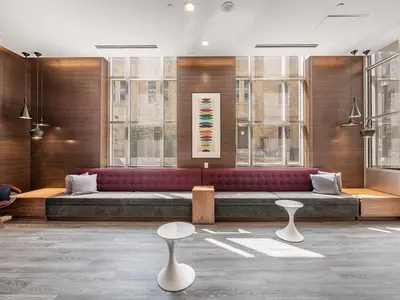 a lobby with a couch and two tables and windows at Prime Downtown Condo - St Lawrence Parking in Toronto