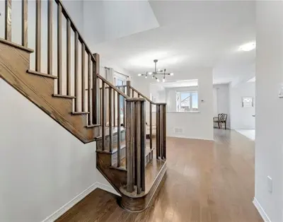 an empty living room with a staircase in a house at Classy Home Near Beach & Airport in Hagersville