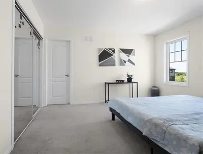 a white bedroom with a bed and a window at Classy Home Near Beach & Airport in Hagersville