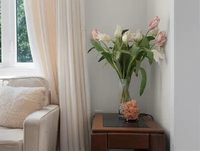 a vase of flowers on a table next to a couch at Classy Home Near Beach & Airport in Hagersville