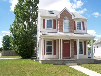 a house with a red door in a yard at Lakeshore North - Waterloo in Waterloo