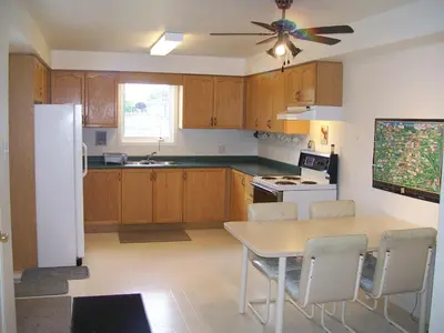 a kitchen with a table and a white refrigerator at Lakeshore North - Waterloo in Waterloo