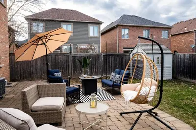 a patio with chairs and an umbrella and a table at Family Retreat. in Milton