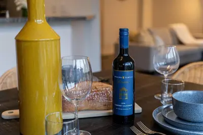 a bottle of wine and two wine glasses on a table at Family Retreat. in Milton