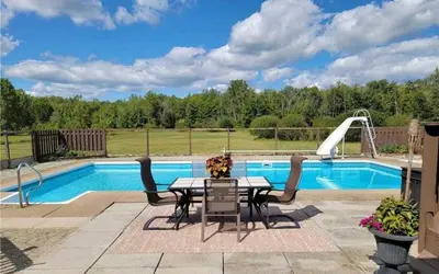 a patio with a table and chairs next to a pool at A getaway in Niagara from hustle bustle in Welland