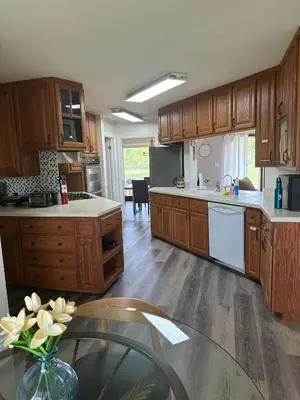 a kitchen with wooden cabinets and a vase of flowers at A getaway in Niagara from hustle bustle in Welland