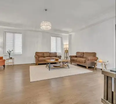 a living room with two couches and a table at Cambridge Luxury by Ravine in Cambridge