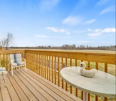 a wooden deck with a table and a swan on it at Cambridge Luxury by Ravine in Cambridge