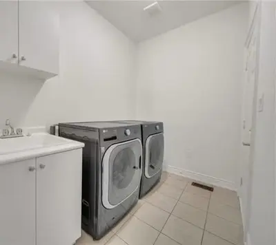 a washer and dryer in the corner of a kitchen at Cambridge Luxury by Ravine in Cambridge