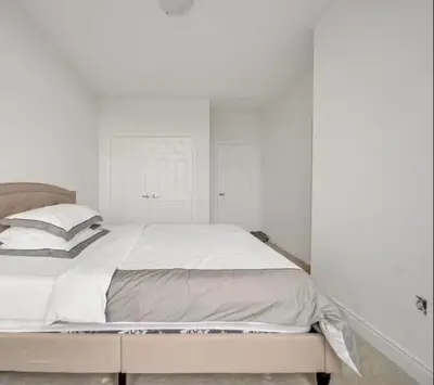 a bedroom with a large bed with white walls at Cambridge Luxury by Ravine in Cambridge