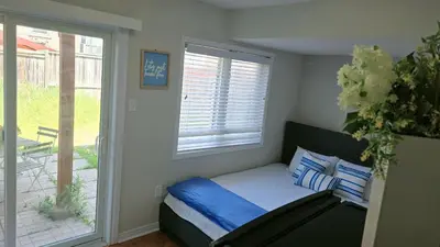a small bedroom with a bed and a window at Beautiful Studio with Patio in Mississauga in Mississauga