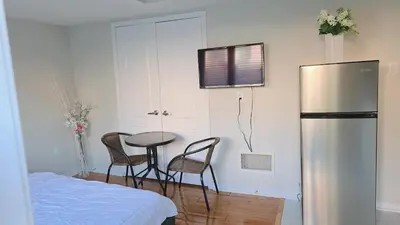 a kitchen with a refrigerator and a table and chairs at Beautiful Studio with Patio in Mississauga in Mississauga