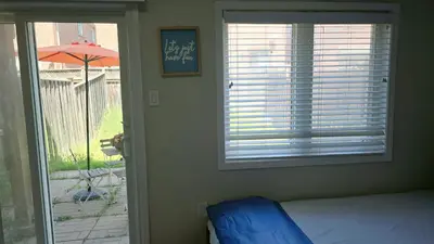 a bedroom with a bed and a window with an umbrella at Beautiful Studio with Patio in Mississauga in Mississauga