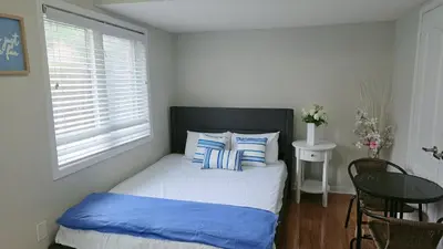 a bedroom with a bed with blue and white pillows at Beautiful Studio with Patio in Mississauga in Mississauga