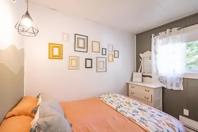 a bedroom with a bed and pictures on the wall at Hills Haven - Luxury Riverfront Cottage in Minden