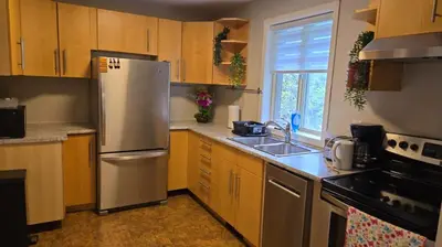 a kitchen with wooden cabinets and a stainless steel refrigerator at \u9a6c\u5361\u59c6\u7684\u5bc4\u5bbf\u5bb6\u5ead- Simple Trip To Toronto in Markham