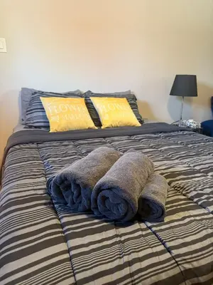 a bed with towels and pillows on it at \u9a6c\u5361\u59c6\u7684\u5bc4\u5bbf\u5bb6\u5ead- Simple Trip To Toronto in Markham