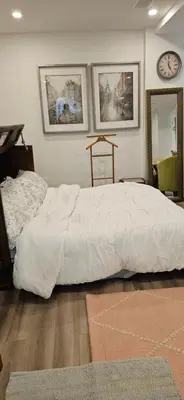 a bedroom with a bed and a clock on the wall at Walk out Basement Studio in Smithville