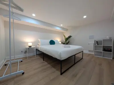 a bedroom with a large bed and a lamp at The Urban Hideaway - Stylish Stay - Prime Spot in Hamilton