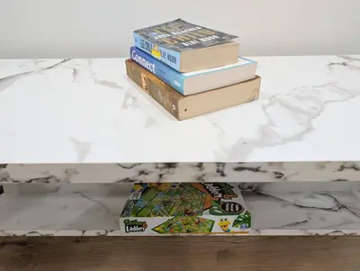a stack of books sitting on top of a table at The Urban Hideaway - Stylish Stay - Prime Spot in Hamilton