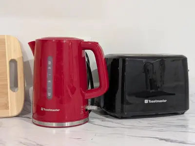 a red cup next to a black toaster at The Urban Hideaway - Stylish Stay - Prime Spot in Hamilton