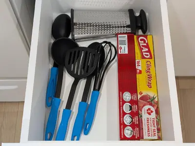 a drawer full of kitchen utensils next to a box at The Urban Hideaway - Stylish Stay - Prime Spot in Hamilton