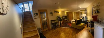 a room with a staircase and a living room at Country Roads Dwelling in Hamilton