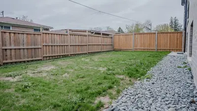 a backyard with a wooden fence and a yard at Upscale Pickering Escape Near Lake & Dining in Pickering