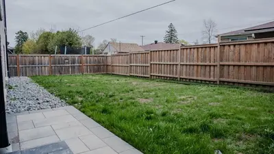 a backyard with a wooden fence and green grass at Upscale Pickering Escape Near Lake & Dining in Pickering
