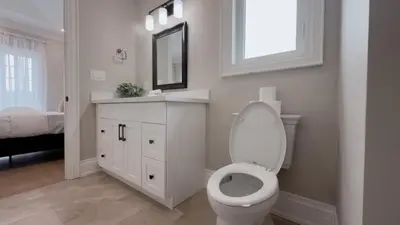 a bathroom with a toilet and a sink and a mirror at Upscale Pickering Escape Near Lake & Dining in Pickering
