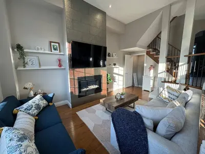a living room with a blue couch and a fireplace at Vibrant and Comfy Mississauga Home 20 mins from YYZ in Mississauga