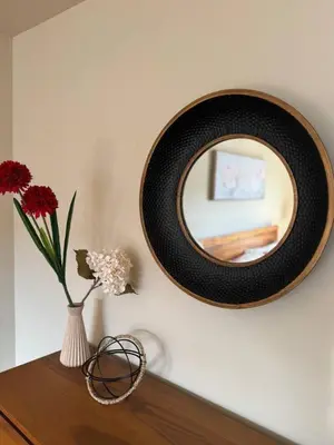 a mirror and a vase with flowers on a table at Vibrant and Comfy Mississauga Home 20 mins from YYZ in Mississauga